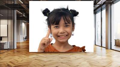 Asian little girl has dark two hair buns and wearing earring pointing his hand up making idea gesture at something and smile isolated on white background. Wall mural