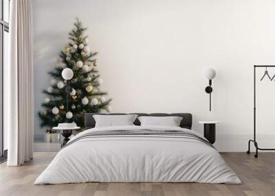 A minimalist Christmas tree decorated with gold and white ornaments, with a blank wall to the side for inserting holiday greetings. Wall mural