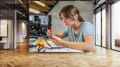 Portrait of a yoing woman repairing desktop computer
Woman wearing protective glasses Wall mural