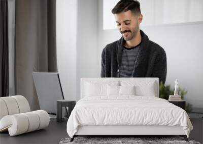 Young Man Shopping Online with Credit Card and Laptop Wall mural