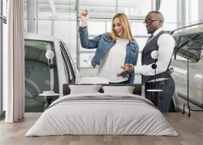 African man in glasses showing a happy girl with her new car Wall mural