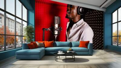 African man with dreadlocks and headphones in the recording Studio singing loudly close-up. Side view Wall mural