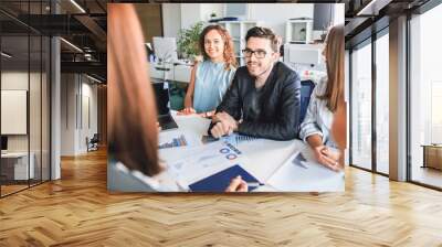 Modern business people talk and smile during a conference in the office Wall mural