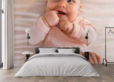 Newborn baby lying on the bed, Dad holding the baby's legs with his hands top view. Vrtical photography Wall mural