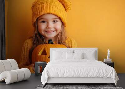 Cheerful Child Holding Carved Halloween Pumpkin on Bright Orange Background Wall mural