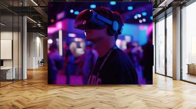 A man wearing a VR headset stands in a room with other people. The room is brightly lit and the man is focused on the virtual reality experience Wall mural