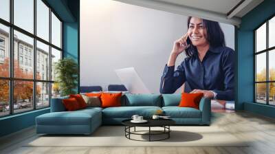 Businesswoman in black shirt talking by mobile phone in office Wall mural