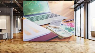 Money USD dollars, yuan RMB, Euro money on laptop with stock exchange on screen for stock exchange investment concept. Wall mural