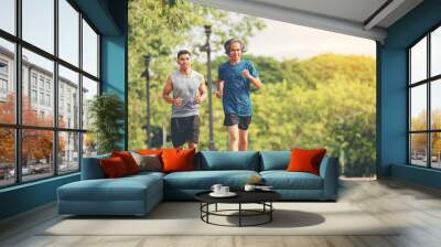 Senior elderly man and a young man running together along the walk path in the park.	 Wall mural