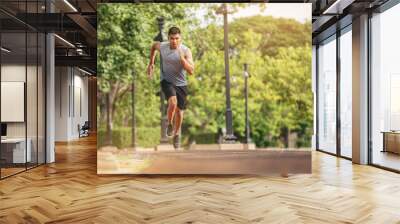 Silhouette of young man running sprinting on road. Fit runner fitness runner during outdoor workout with sunset background. Wall mural