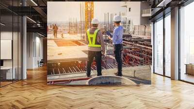 Structural engineer and foreman worker with touch pad discuss, plan working for the outdoors building construction site. Wall mural