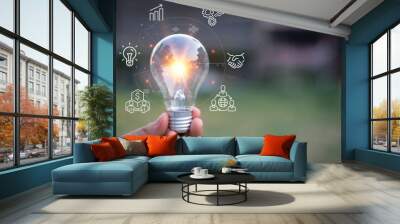 holding a bright light bulb. Concept of Ideas for presenting new ideas Great inspiration and innovation new beginning.Green background Wall mural