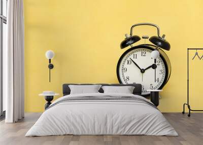 Alarm Clock analog classic vintage retro style black on pale yellow background and copy space. Wall mural