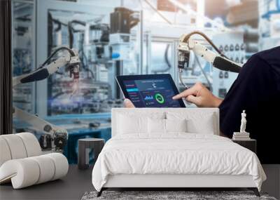 Smart industry control concept.Hands holding tablet on blurred automation machine as background Wall mural