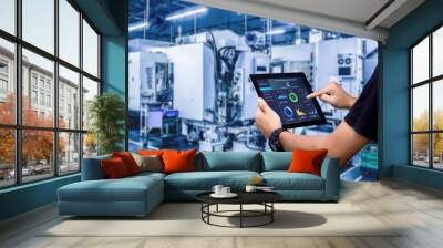 Smart industry control concept.Hands holding tablet on blurred automation machine as background Wall mural