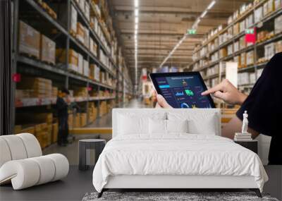 Smart warehouse management system.Worker hands holding tablet on blurred warehouse as background Wall mural