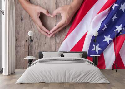 Gesture made by hands showing symbol of heart with american flag on old wooden background. Wall mural