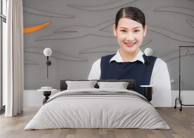 Portrait of attractive authentic Asian woman maid smiling in uniform standing with crossed hands and looking at the camera. Cleaning Service concept. Wall mural