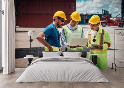 Three smart engineer man wearing safety helmet doing stock tick check and tablet stock container management in container yard background.. Wall mural