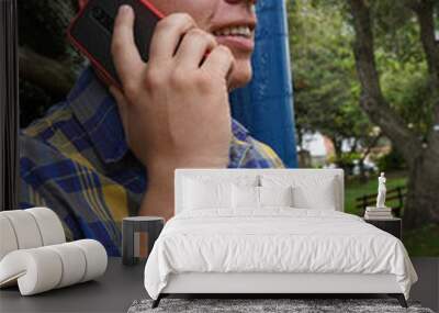 Blond man talking on cell phone making a call outside on the street Wall mural