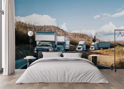 Convoy of white trucks with containers on the road, cargo transport concept, at dusk. Wall mural