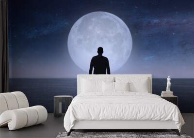 A man looks at the stars and the moon.  Elements of this image furnished by NASA. Wall mural