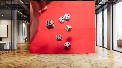 Hand throwing dice, hoping for the best odds. Six dice on red background Wall mural