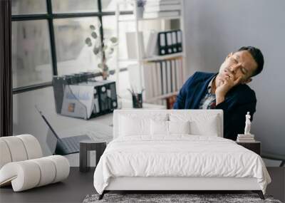 Businessman Taking a Nap at Desk in Modern Office with Documents and Laptop Wall mural