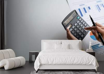 Close up view of businesswoman using calculator to estimate the budget for company. Wall mural