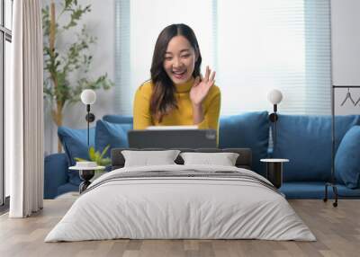 Young Woman in Yellow Sweater Having a Video Call on Tablet in Modern Living Room Wall mural