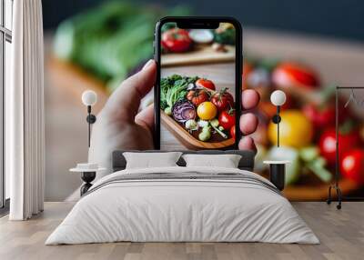 A hand is holding a cellphone displaying food products Wall mural