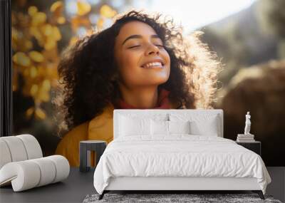 A latin woman breathes calmly looking up enjoying autumn air Wall mural