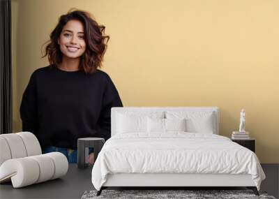 An Indian woman wearing black sweatshirt isolated on pastel background Wall mural