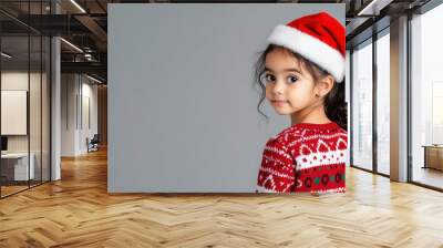 Arabian little girl in christmas wear with red santa claus hat isolated Wall mural