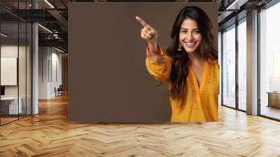 Happy indian woman pointing her finger at copy space for promotion Wall mural