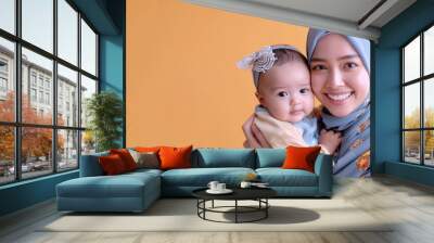 Malay mother holding her baby with her arm and lifting up playing fun Wall mural