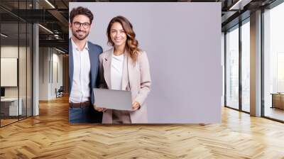 Multiracial pair of businesspeople holding laptop computer Wall mural