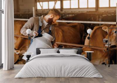 Bearded handsome young man Worker with Jugs of natural healthy milk on background cowhed, sunlight. Banner farm business, industry of eco dairy factory Wall mural