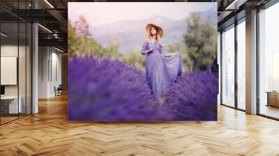 Beautiful girl walks among lavender fields, France, Provence Wall mural