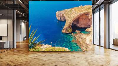 Blue Grotto in Malta. Pleasure boat with tourists runs. Natural arch window in rock Wall mural