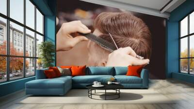 Close-up, master hairdresser does hairstyle with scissors comb. Concept Barbershop Wall mural