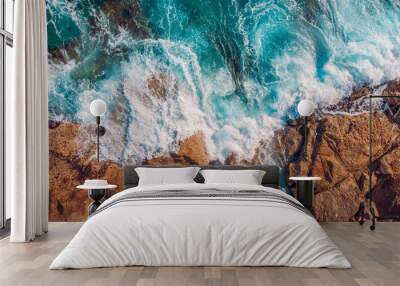 Coast of desert island with blue turquoise water beats on rocky reef. Aerial top view. Wall mural