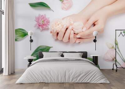 Concept beauty skin care. Beautiful stylish trendy female pink manicure with flower on background, top view Wall mural