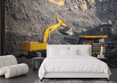 Hydraulic excavator loads coal into body of large yellow mining truck. Open pit mine industry for anthracite Wall mural