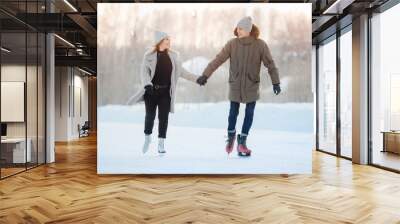 Ice skating lover couple having fun on snow winter holidays Wall mural