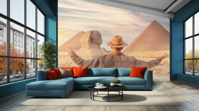 Travel man in hat background pyramid of Egyptian Giza and Sphinx, sunset Cairo, Egypt Wall mural