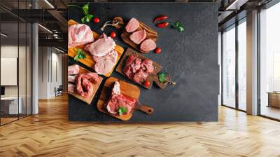 Variety of raw beef meat and pork ribs, pig steaks for grilling with seasoning on wooden board, dark rustic background copy space Wall mural