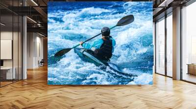 Whitewater kayaking, extreme sport rafting. Back view young woman in kayak sails mountain river Wall mural