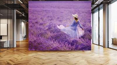 Woman in lavender flowers field at sunset in purple dress. France, Provence. Wall mural