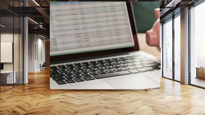 A detailed budget spreadsheet on a laptop, with a piggy bank and calculator beside, illustrating fiscal diligence Wall mural